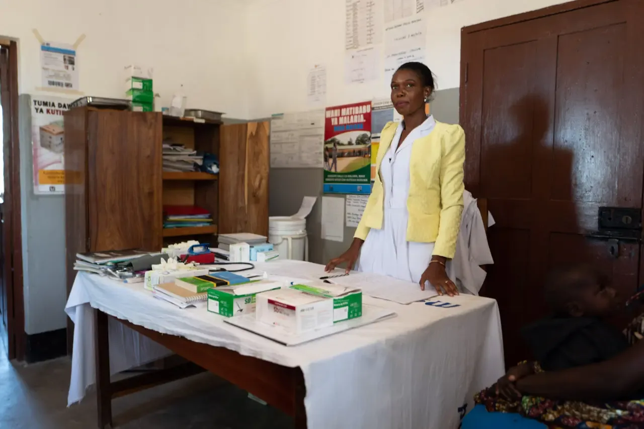 A nurse behind a table of medicine in a health centre