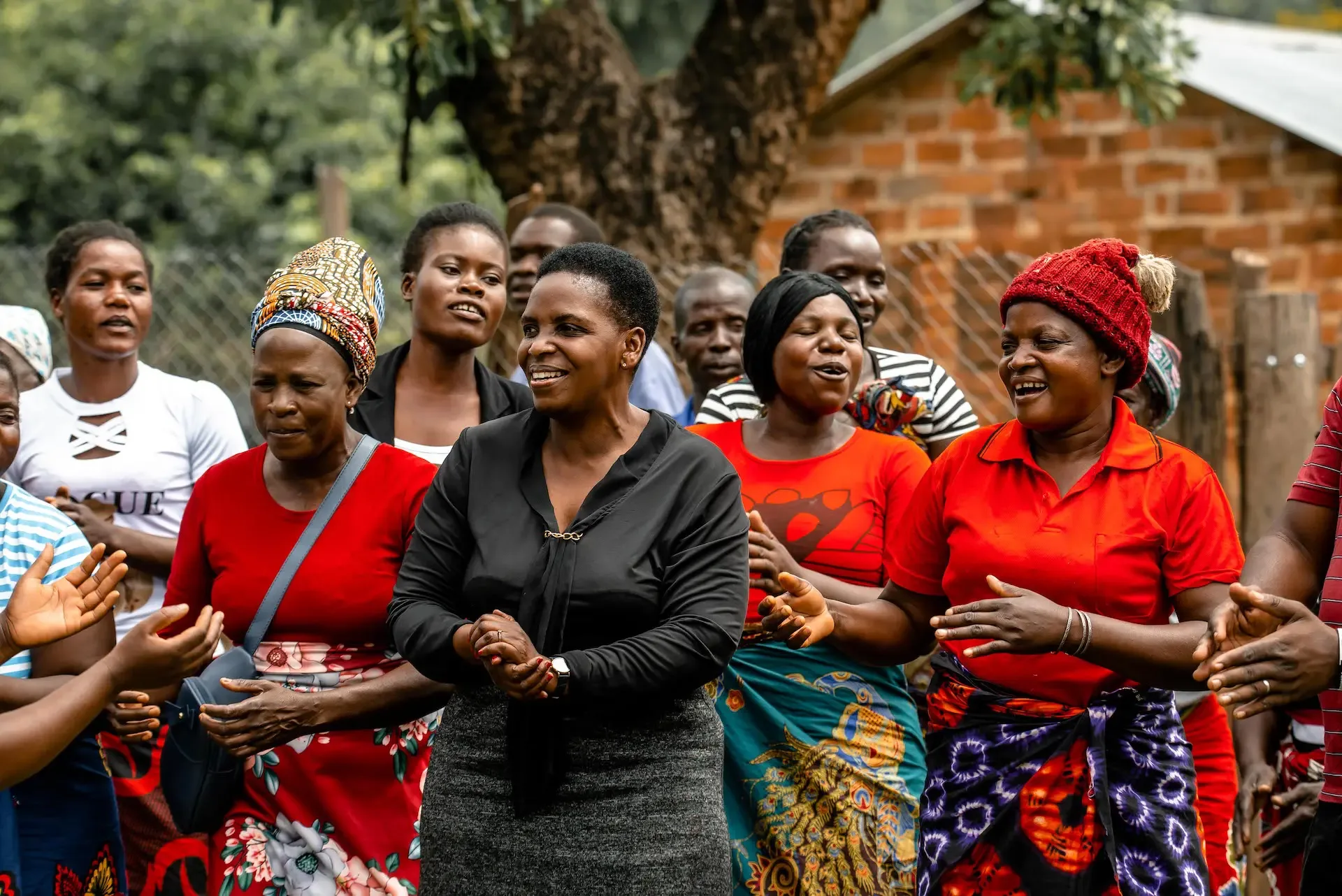 A group of women singing and clapping together