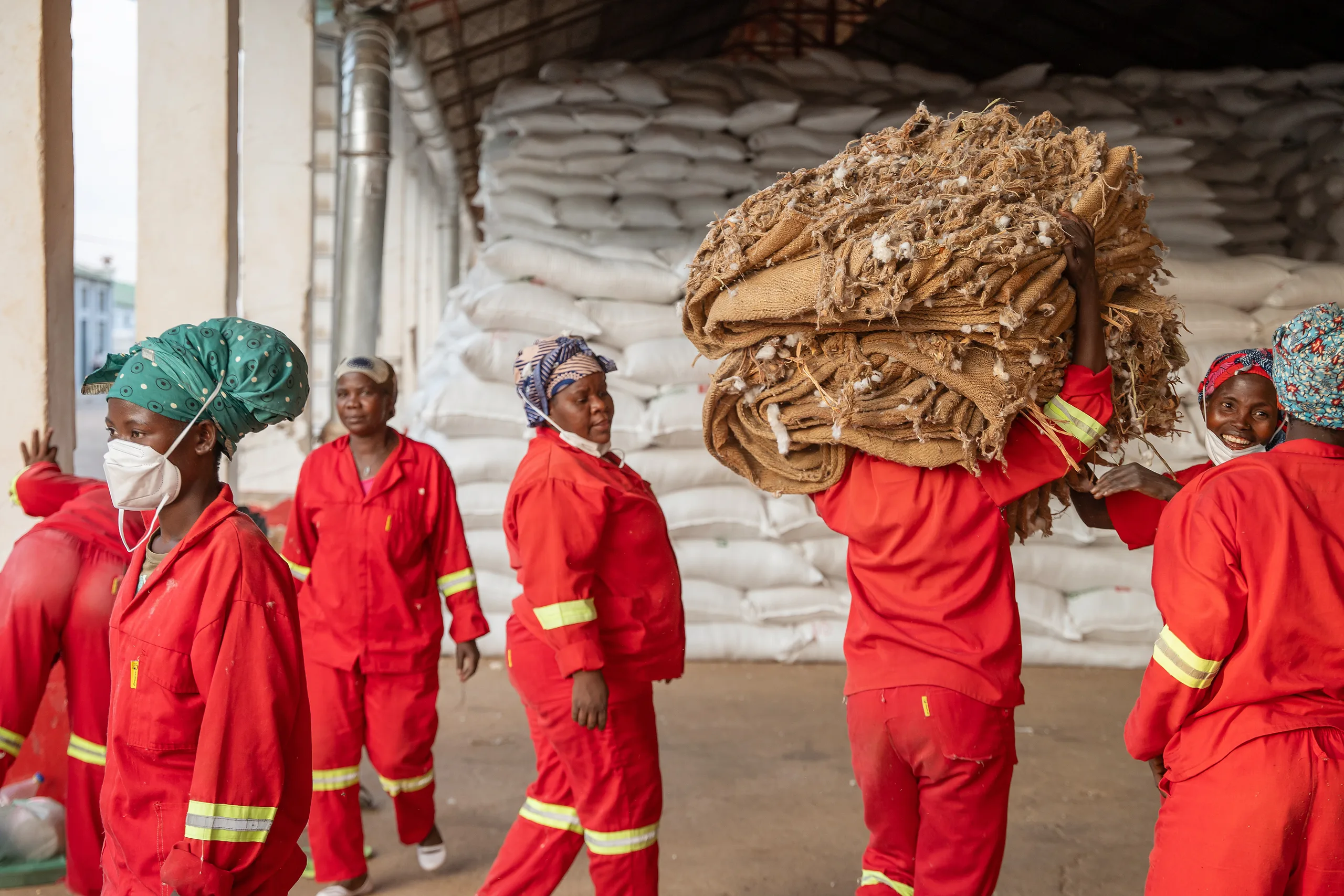 Workers carrying bundles through a warehouse