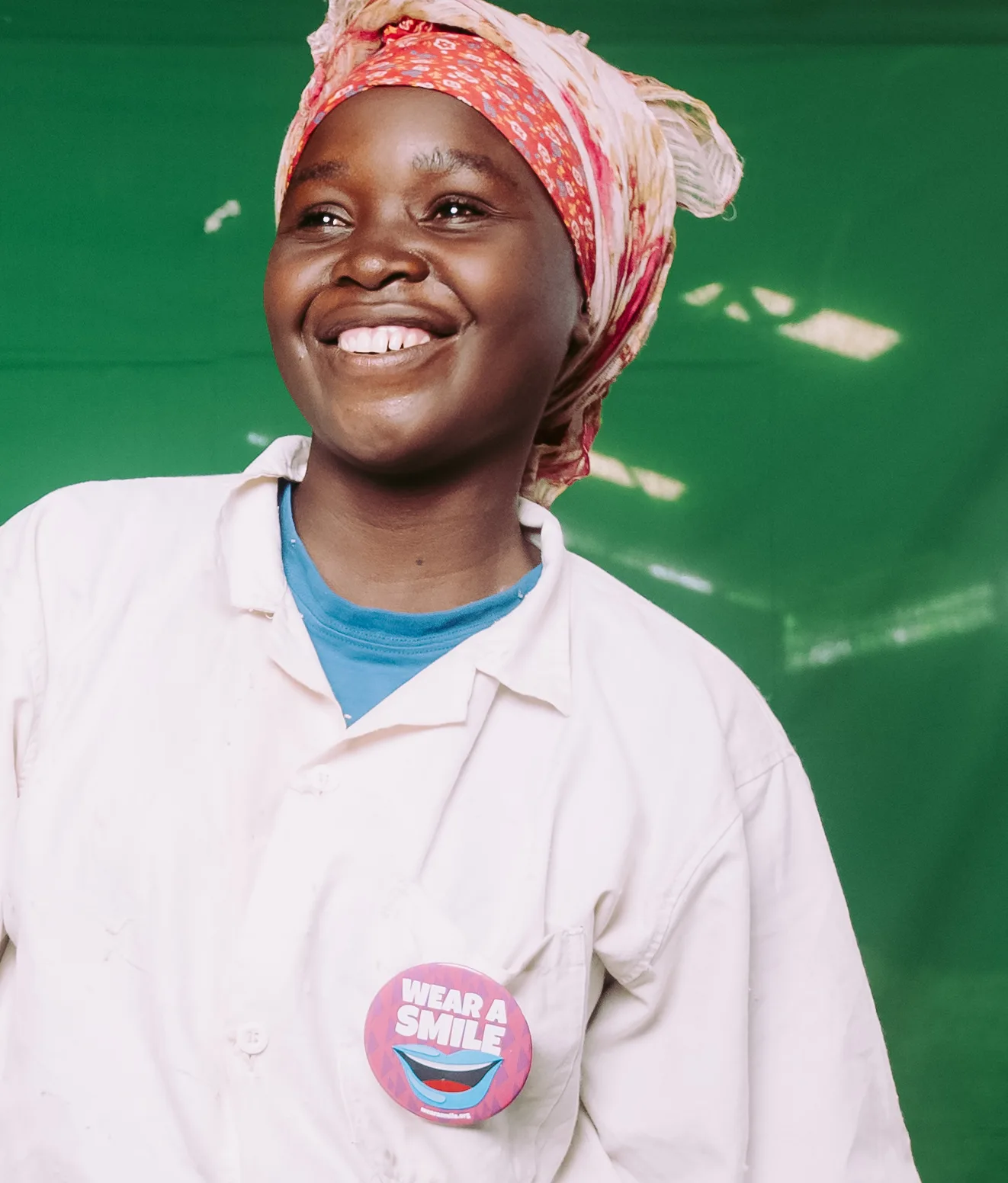 A smiling woman in a white coat