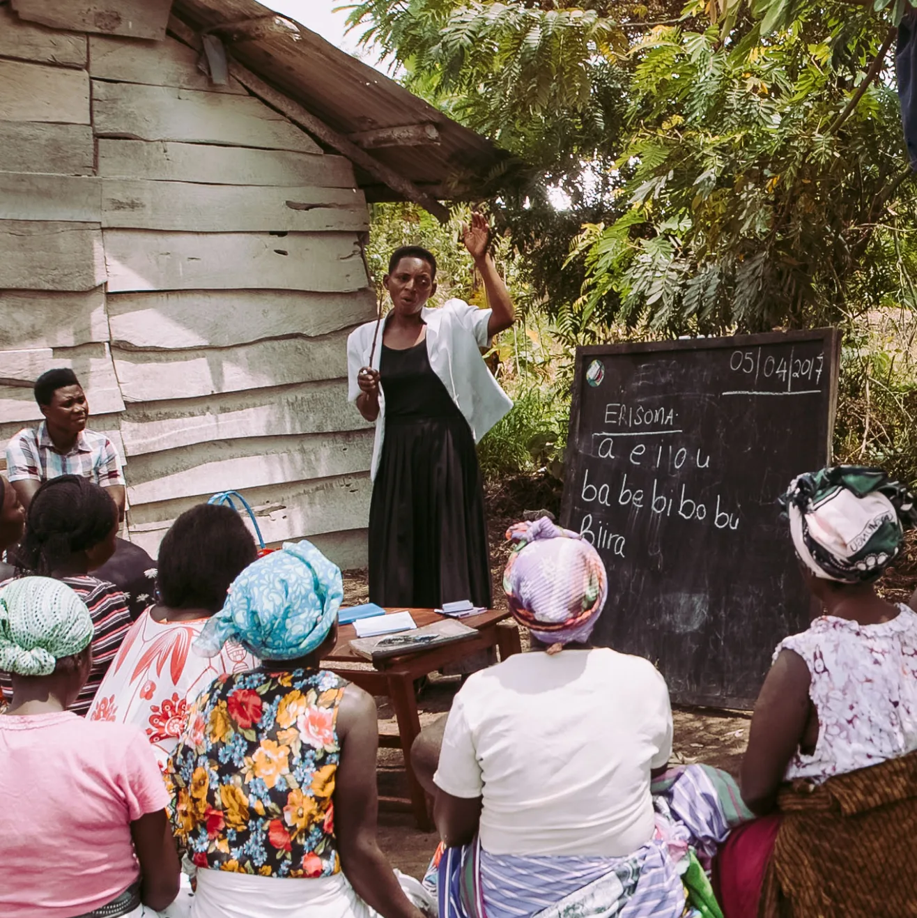A village meeting around a blackboard